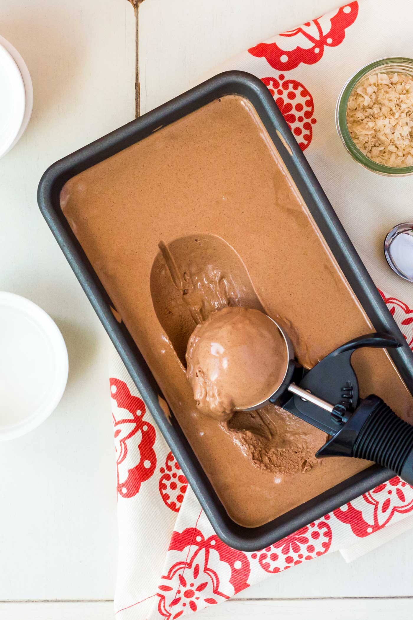 Homemade ice cream in a loaf pan with a scoop resting in it