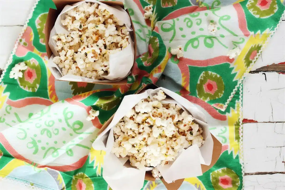 Homemade popcorn in two lined cartons seen from above on a printed cloth