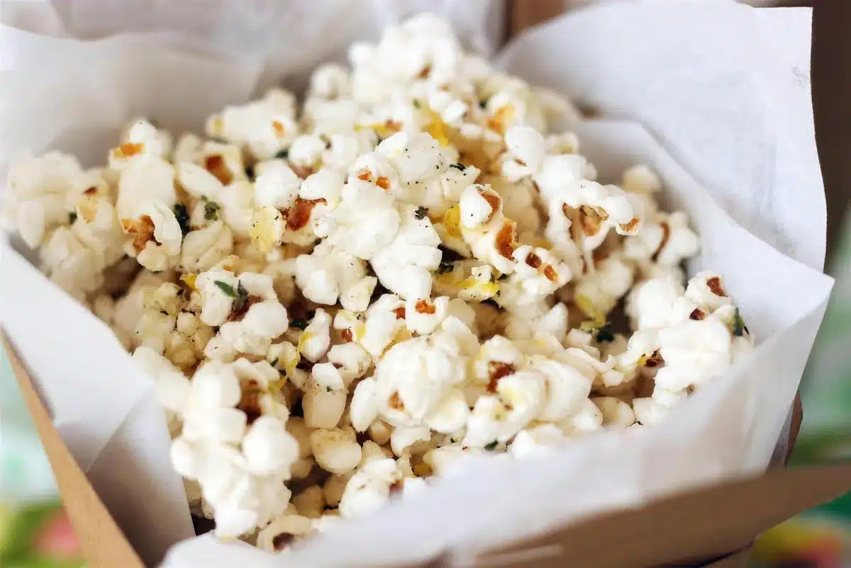 Close view of buttered popped corn in a parchment lined carton