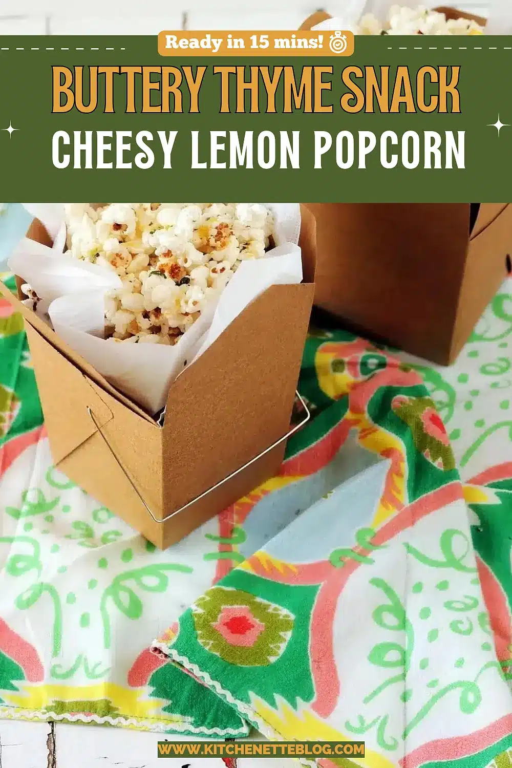Two paper takeout cartons of herb flecked popped corn on a bright cloth