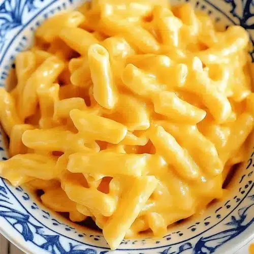 Creamy elbow pasta served in a patterned blue bowl
