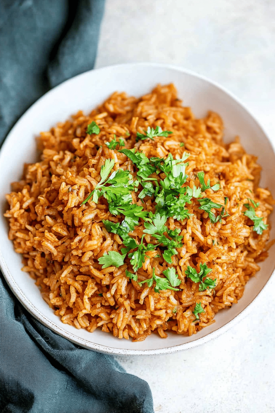 Golden seasoned rice pilaf with herbs in a serving bowl.