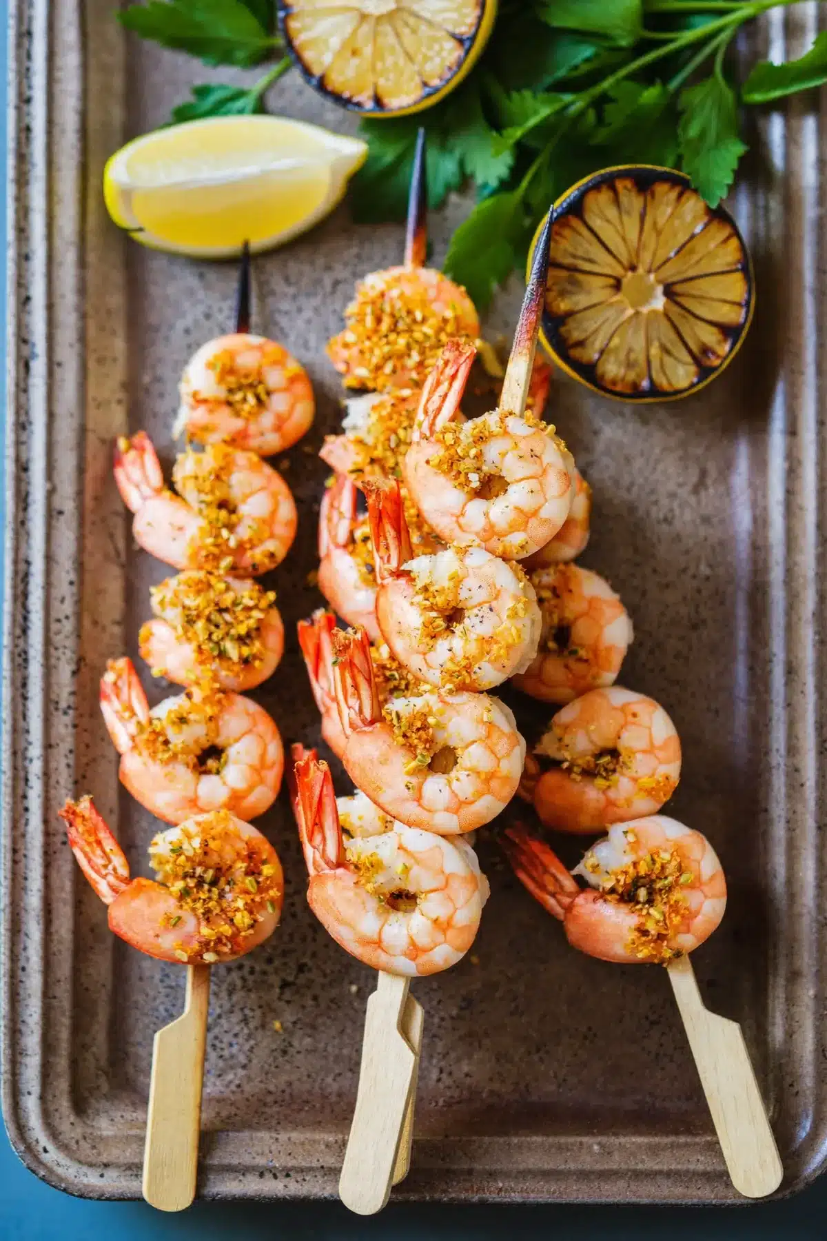 Smoky shrimp kebabs on wooden skewers with charred lemon