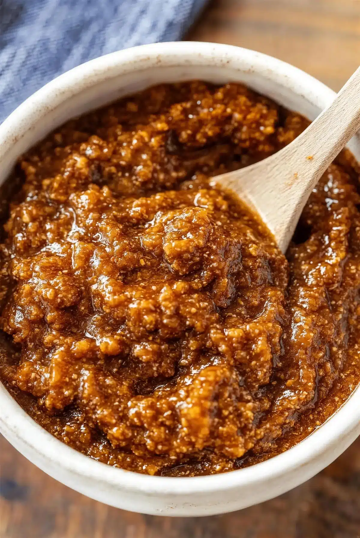 Wooden spoon standing upright in a bowl of coney sauce
