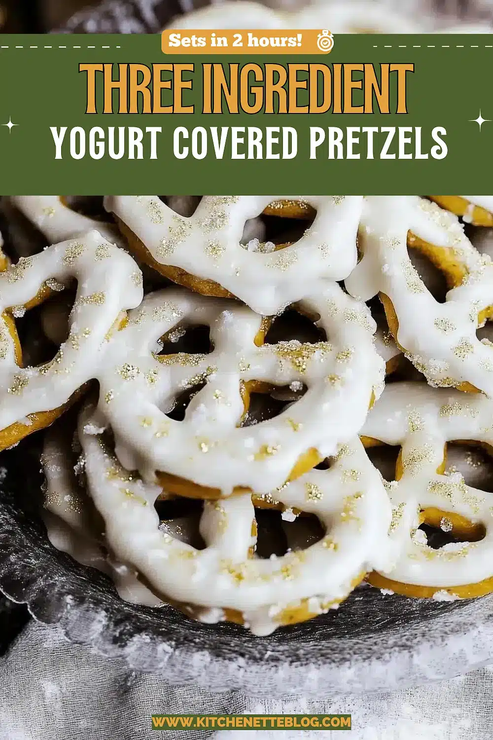 White coated pretzel twists piled on a glass cake stand with gold sprinkles