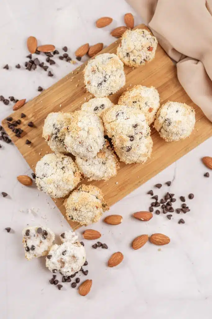 Almond Joy cookies arranged on a bamboo board with a beige napkin alongside