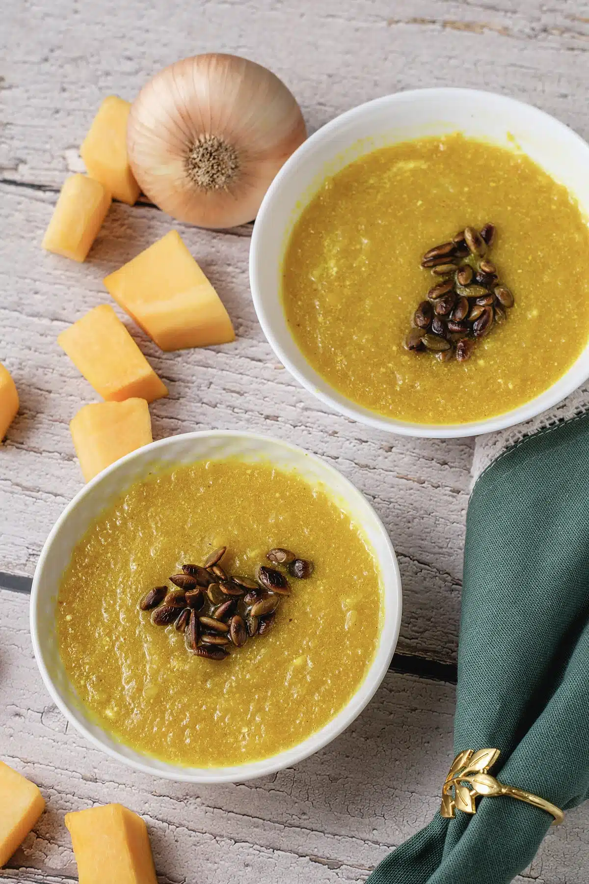 Panera autumn squash soup in two bowls with pepitas and a green napkin