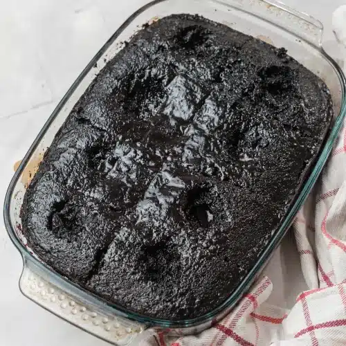 The soaked cake after chilling, the filling set glossy in the holes