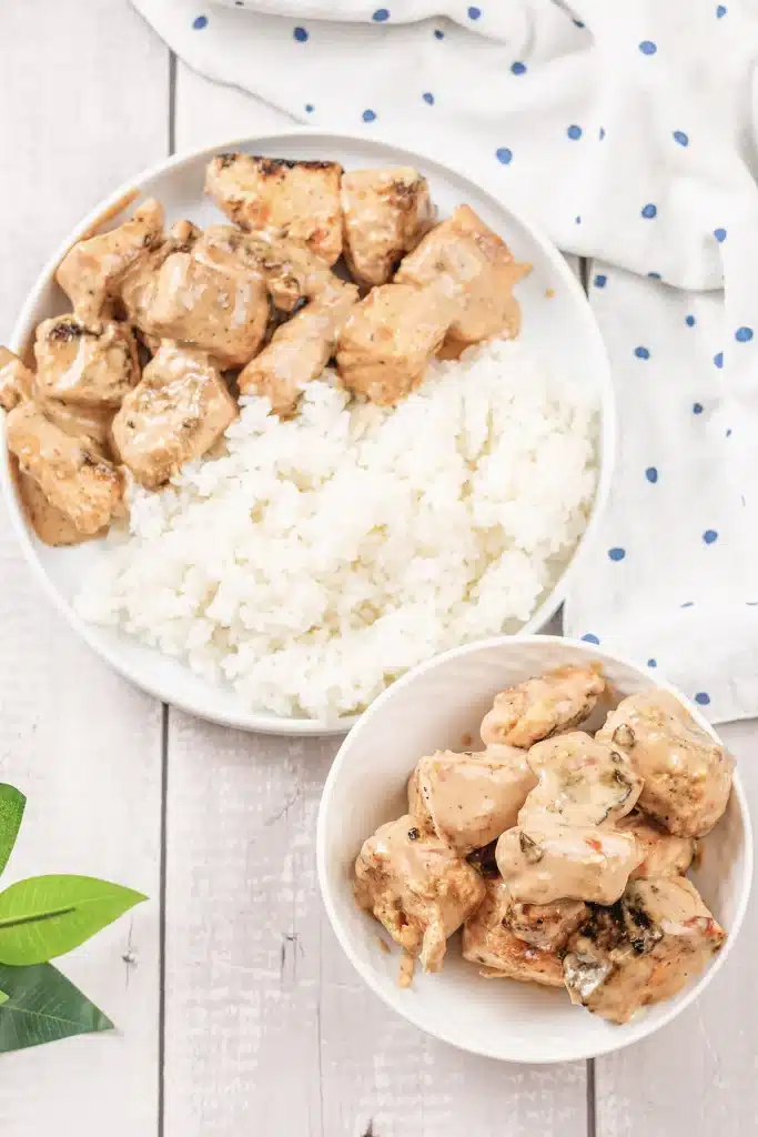 Bang bang salmon bites on a plate of rice seen from directly above