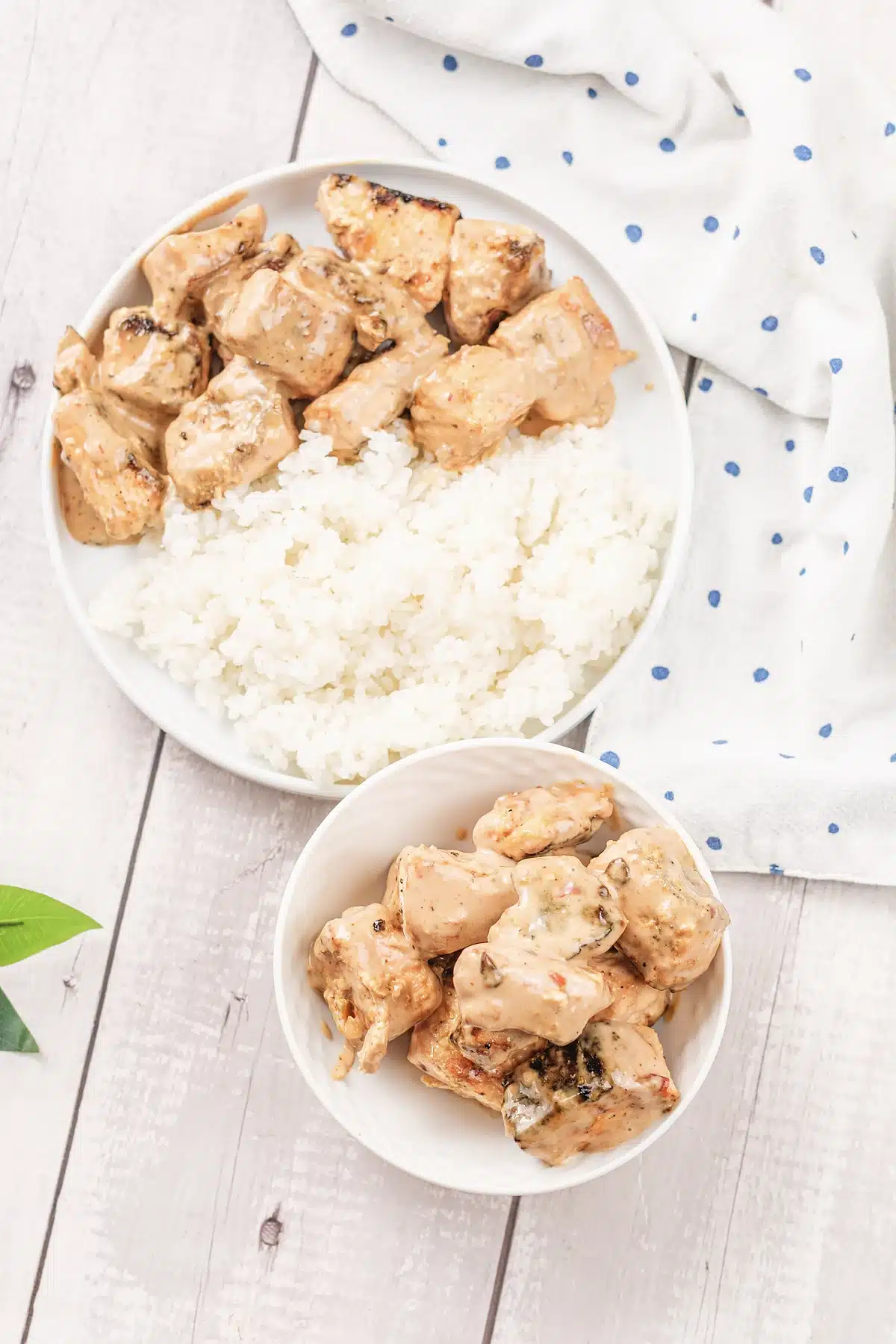 Bang bang salmon bites heaped in a small dish next to steamed rice