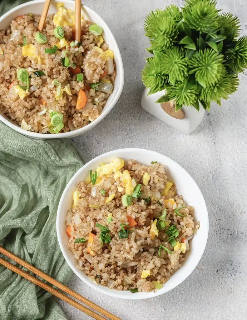 Benihana fried rice served in two white bowls on a pale grey table