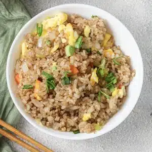 A single bowl of Benihana fried rice topped with sliced scallions