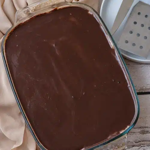 Chocolate ganache spread over the pudding layer in the glass dish