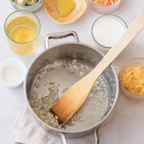 Chopped onion softening in melted butter in a steel pot