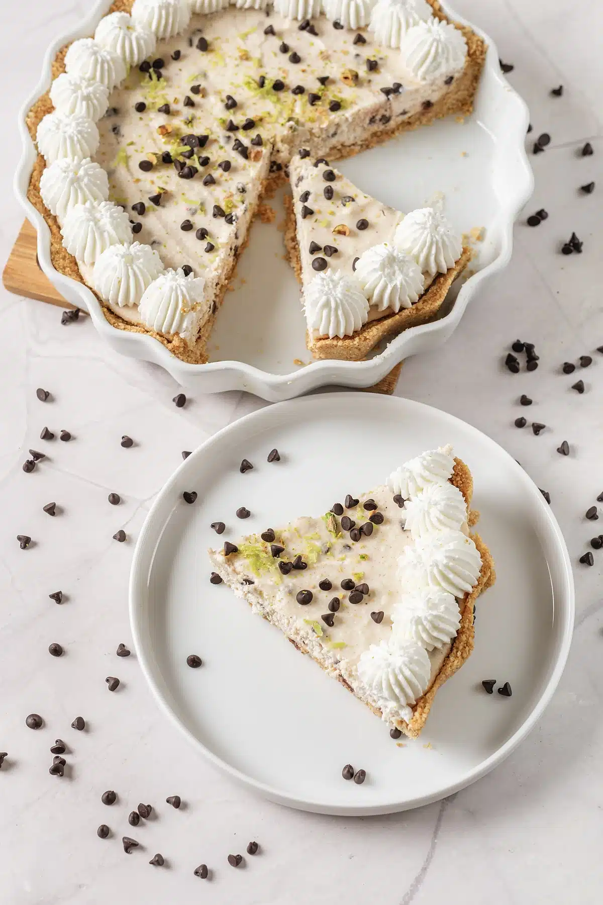 Cannoli pie with one slice lifted out onto a small white plate