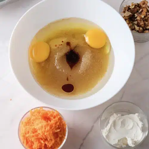 Eggs, sugar, oil and a spoonful of vanilla in the bowl before whisking