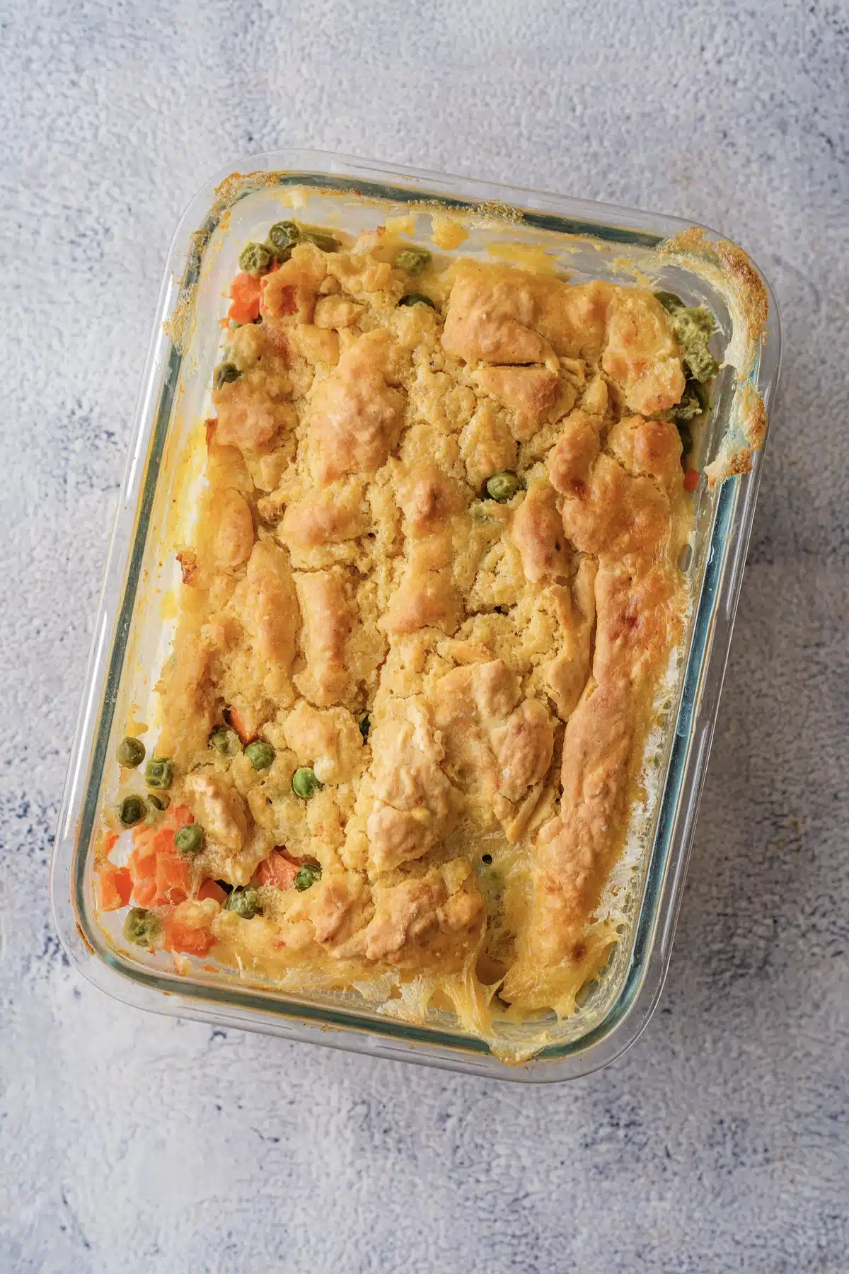 Red Lobster chicken cobbler in a glass dish with a craggy golden biscuit top and peas and carrots at the edges