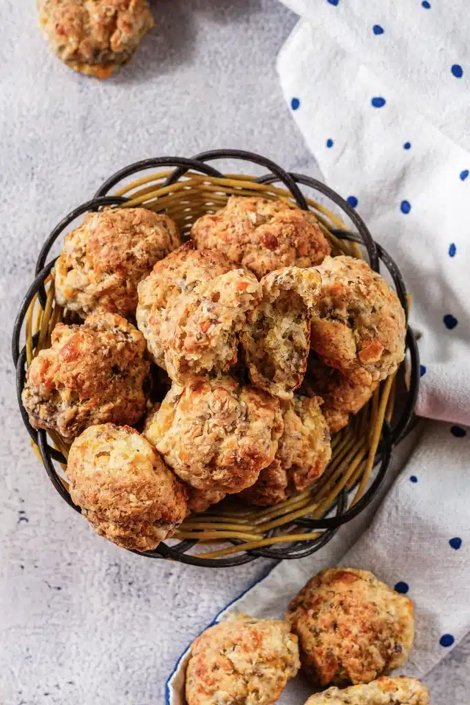 Cheddar bay sausage balls seen from directly above, heaped in a round wire basket