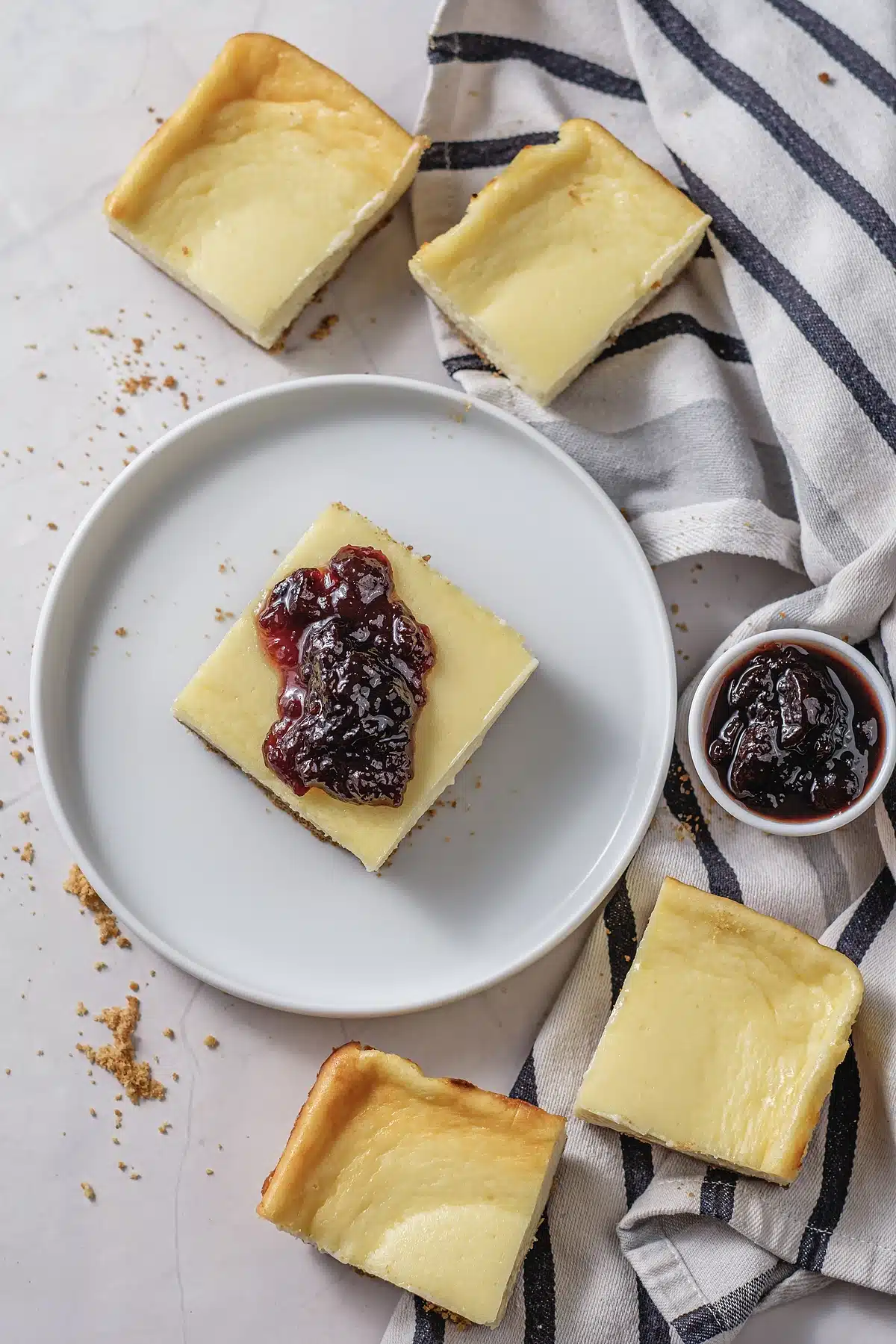 Cherry cheesecake bars seen from above with a small pot of fruit filling