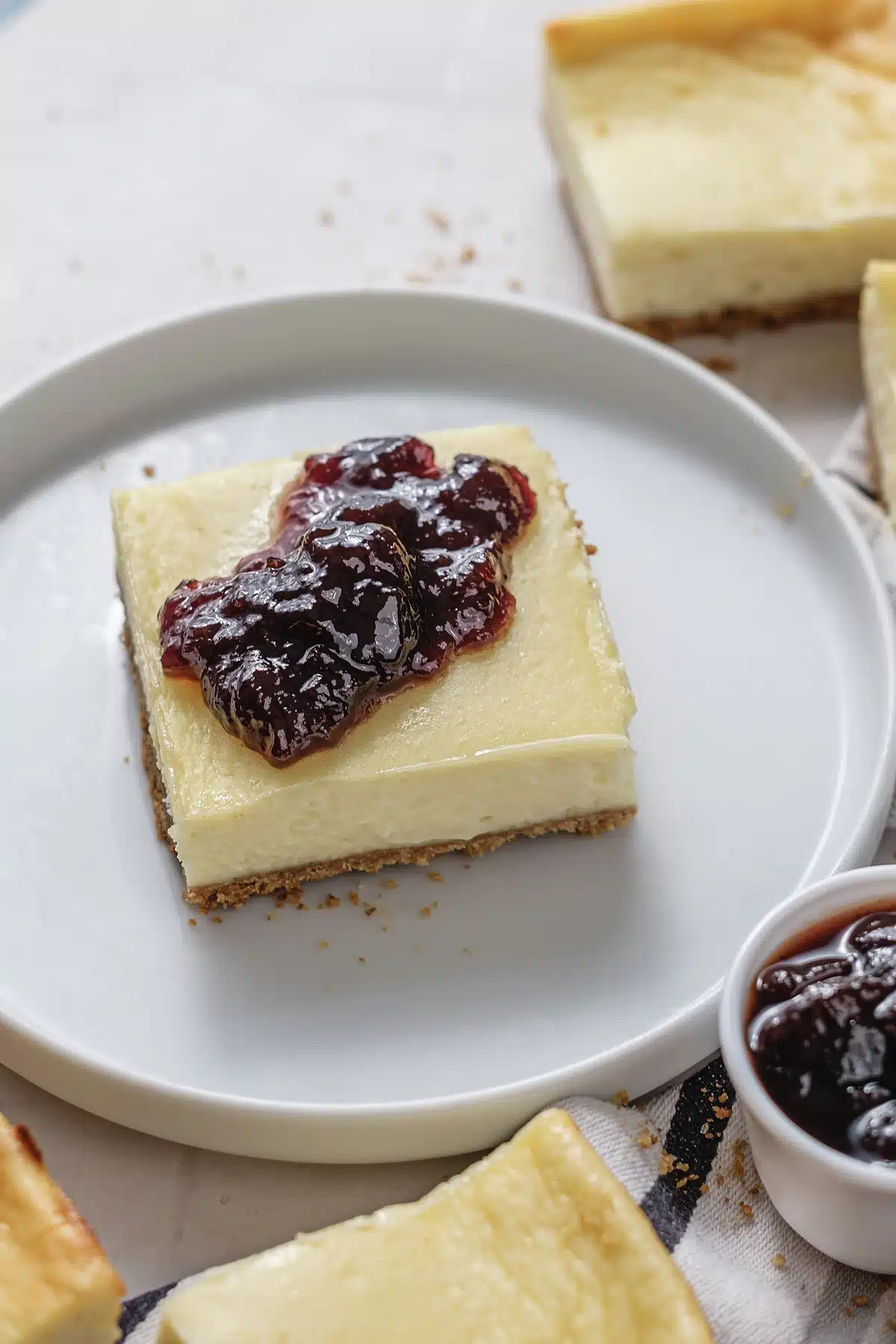 Cherry cheesecake bars close up, showing the graham crust under the cream layer