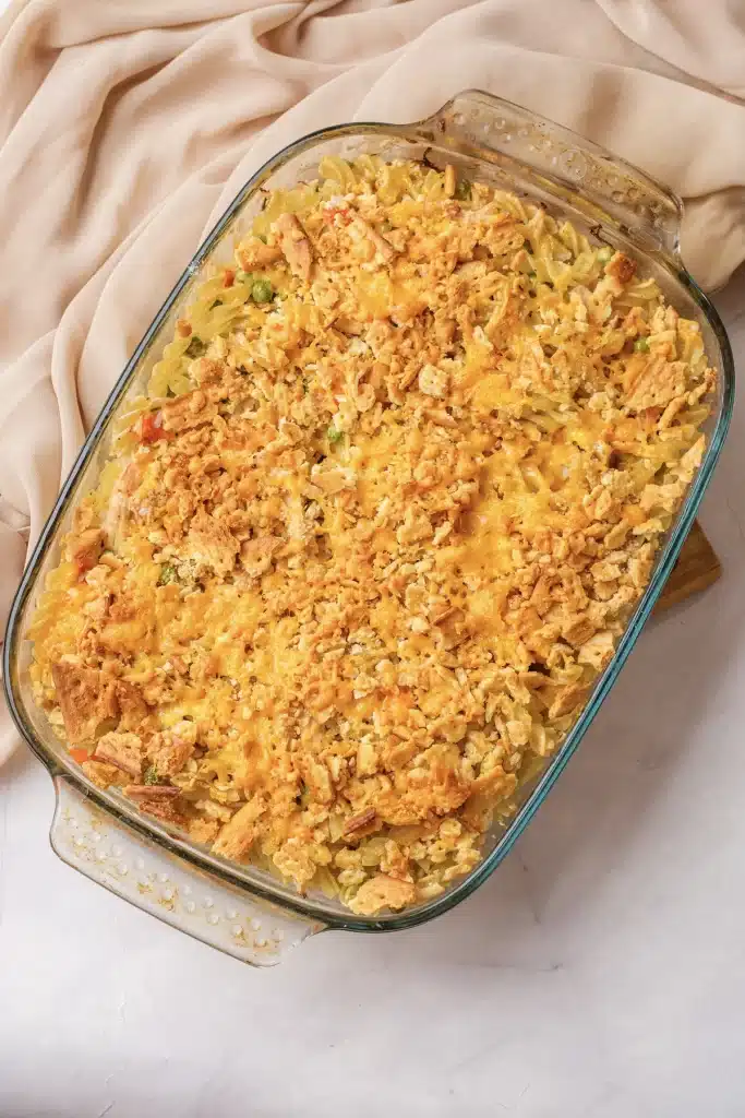 Creamy chicken noodle casserole, rotini version, baked golden in a glass dish seen from directly above