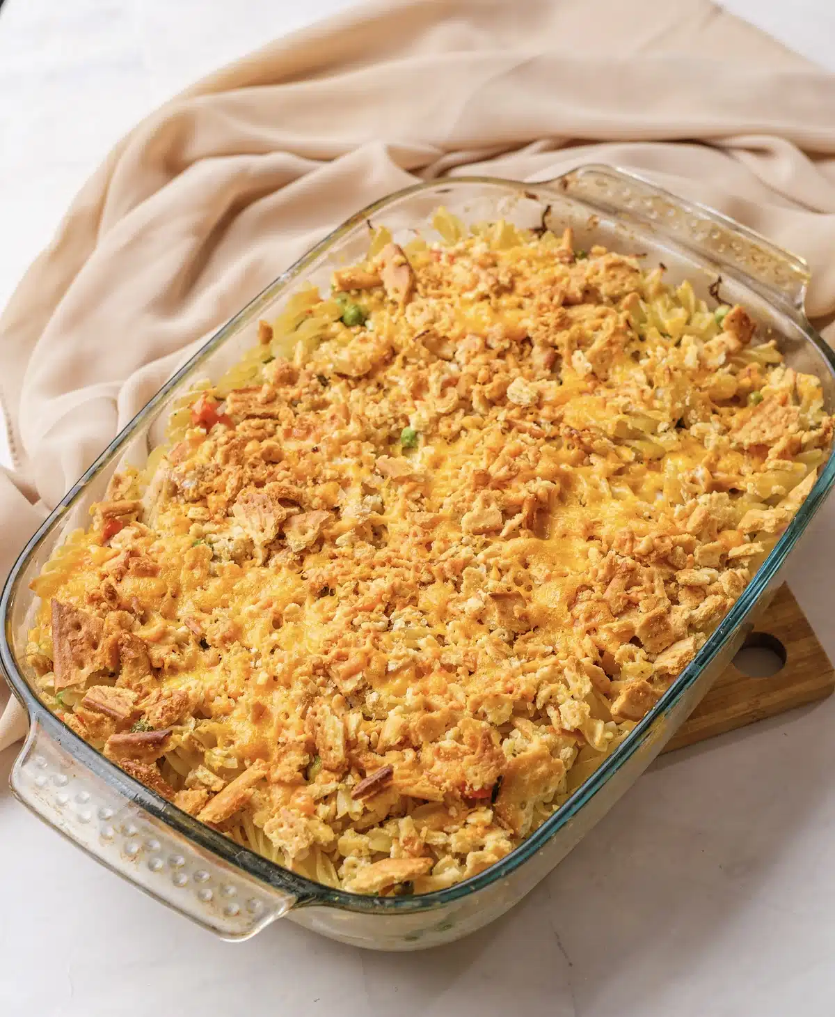 The whole baked dish with spirals of pasta showing under the golden cracker crust