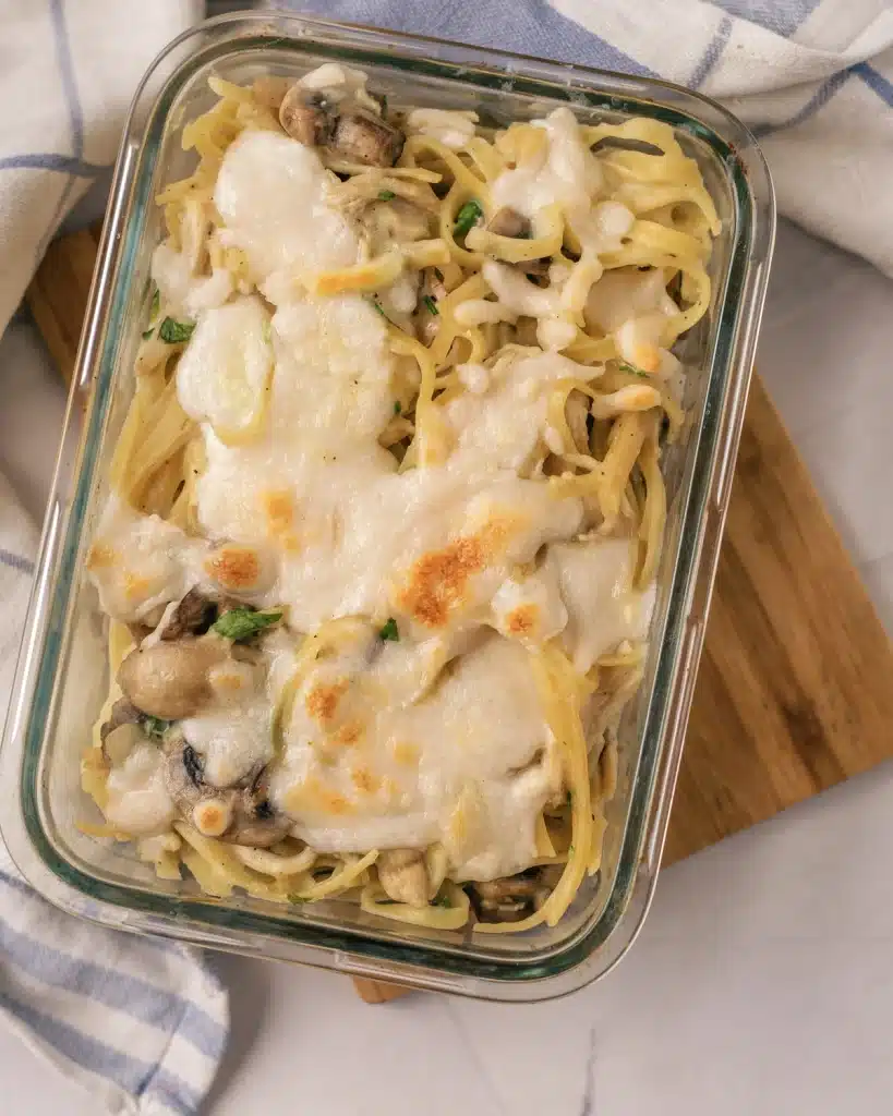Chicken tetrazzini casserole seen from directly above in a glass dish, cheese browned in patches