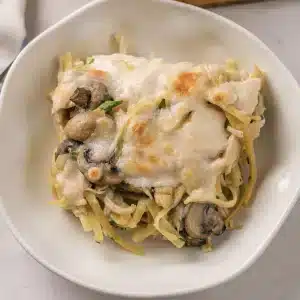 A single square of chicken tetrazzini on a white plate