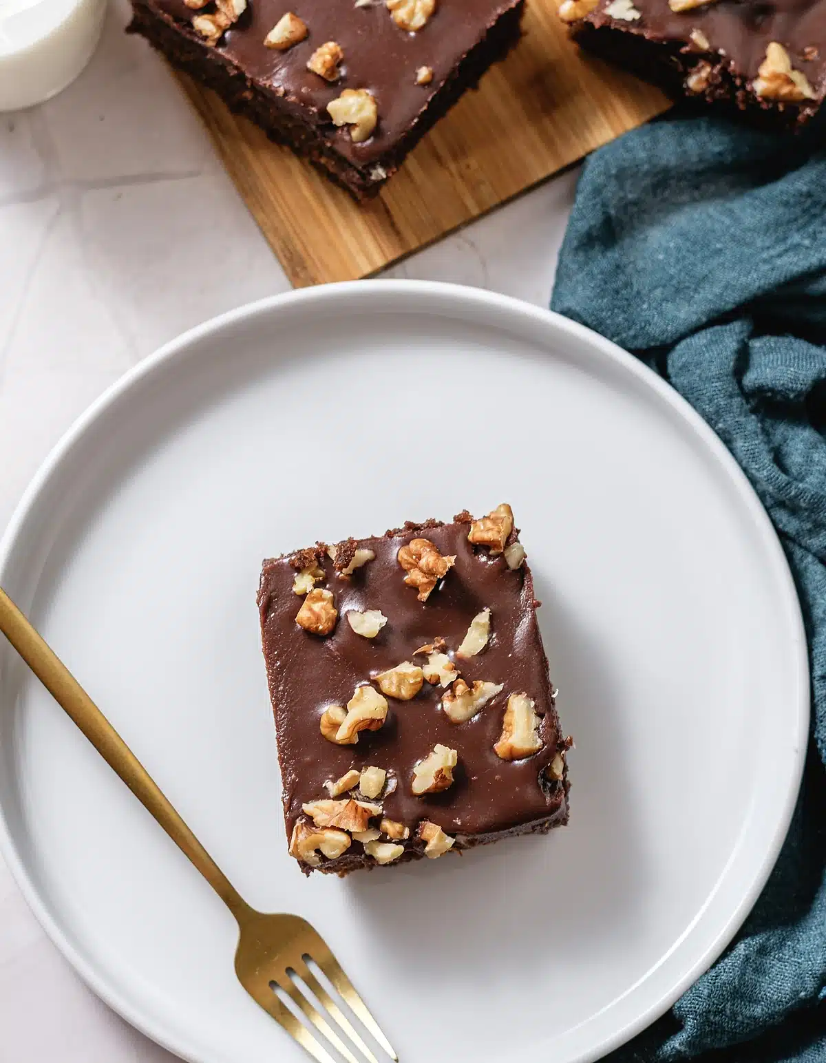 Chocolate buttermilk cake, one square centred on a white plate with a fork