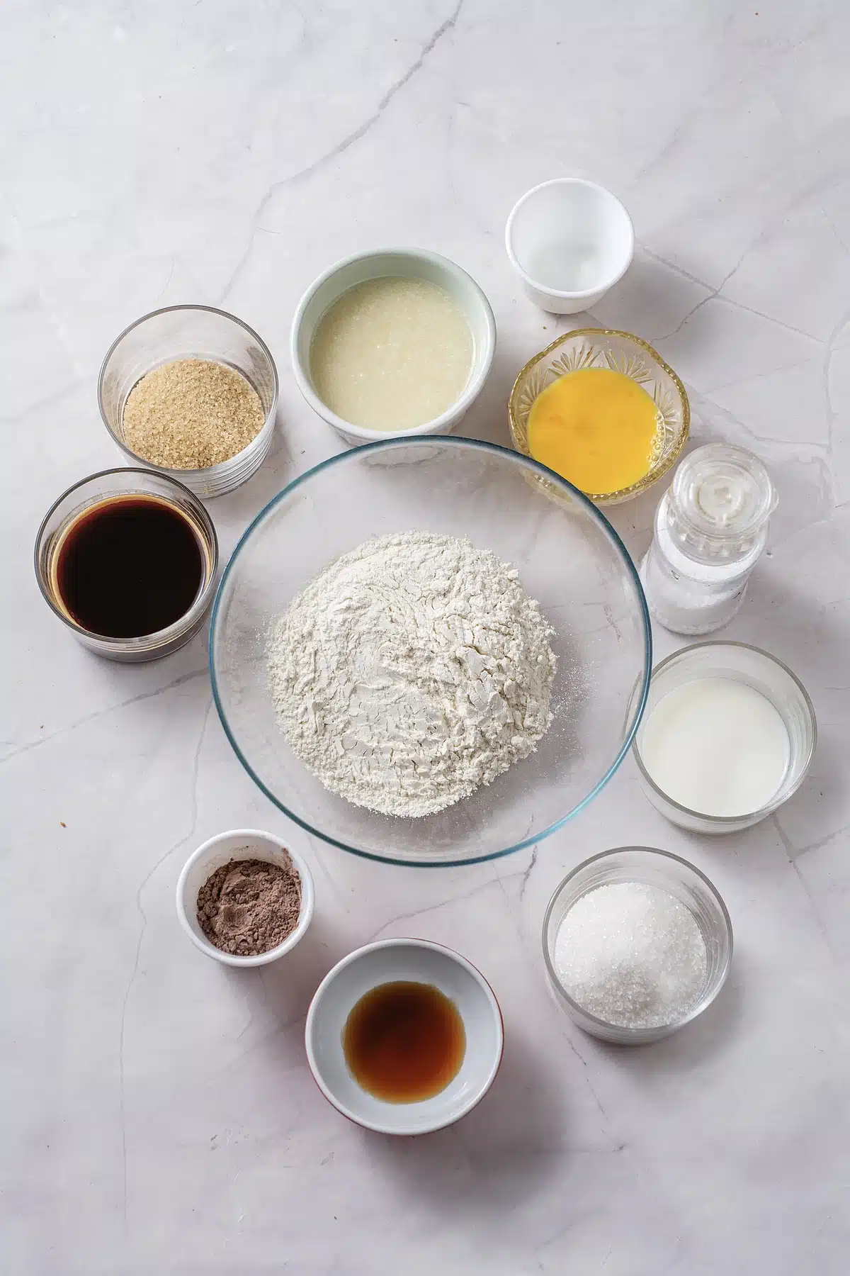 Flour, sugar, cocoa, eggs, oil, milk and vanilla measured into glass bowls
