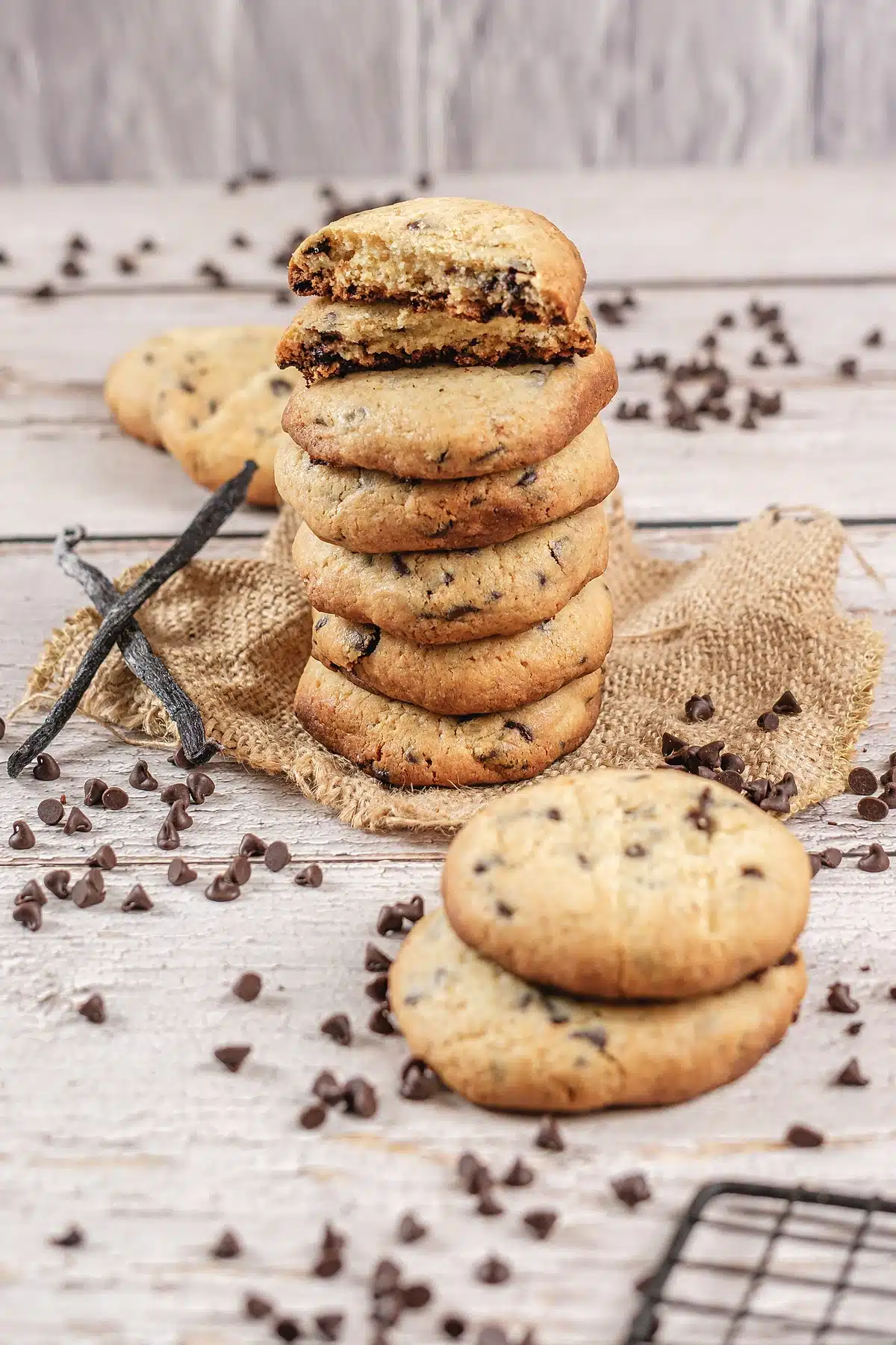 Chocolate chip pudding cookies stacked on burlap with one broken open on top