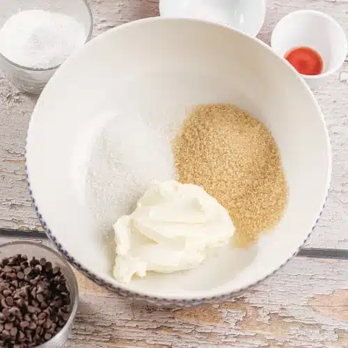 Butter and both sugars in a white mixing bowl before beating