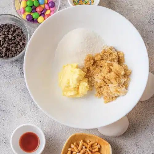 Softened butter, white sugar and brown sugar together in a white bowl before creaming
