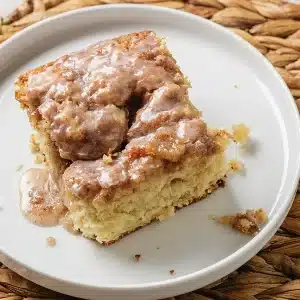 A single square of cinnamon roll coffee cake on a small white plate
