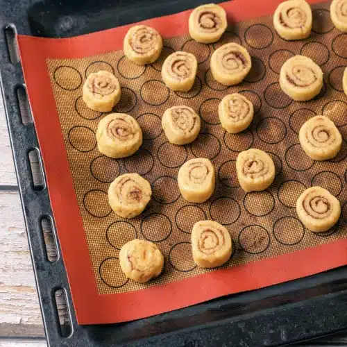 Sliced spirals arranged on a silicone mat on a baking sheet