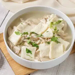 A single bowl of Cracker Barrel chicken and dumplings with parsley