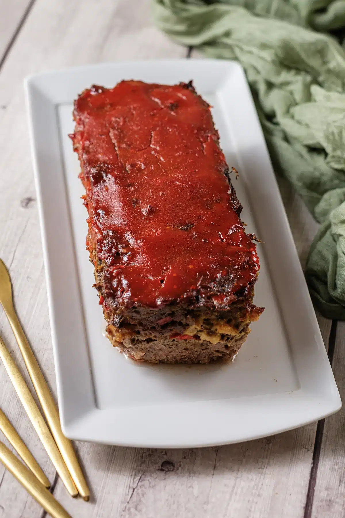 Cracker Barrel meatloaf whole on a white platter with a glossy tomato glaze