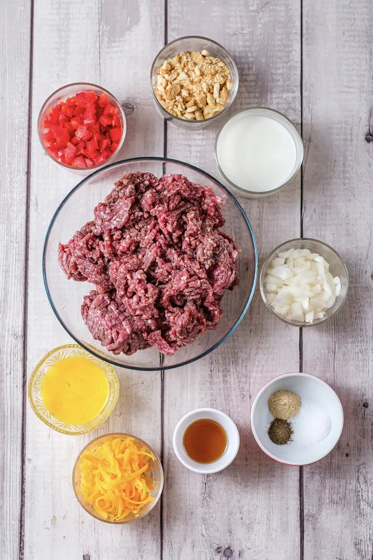 Ground beef, crushed Ritz crackers, cheddar, onion, egg and milk in glass bowls