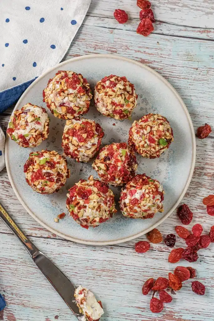 Cranberry pecan cheese ball bites arranged on a stoneware plate, seen from above