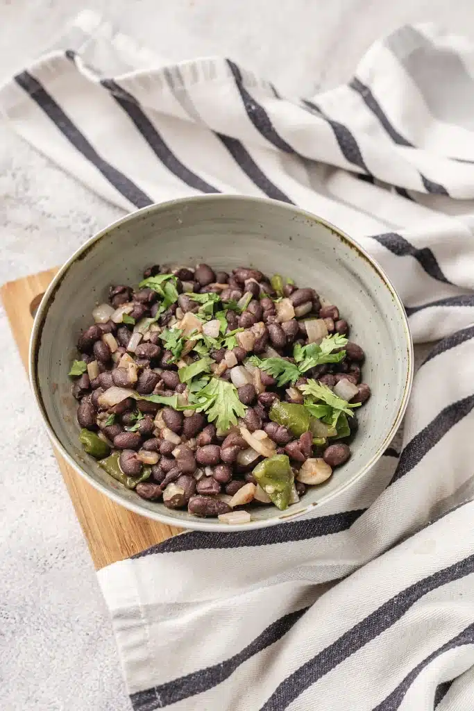 Cuban black beans seen from directly above in a speckled stoneware bowl