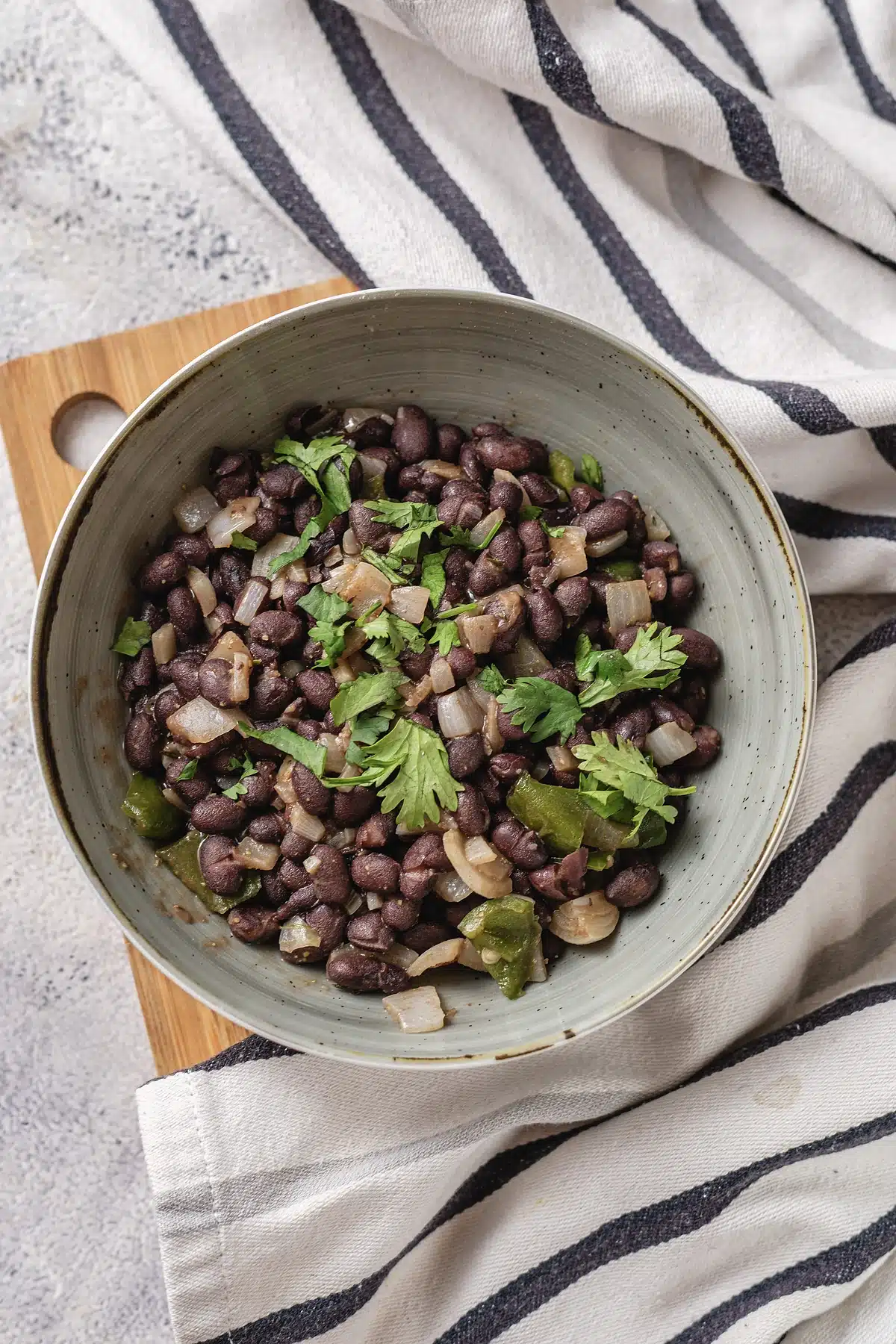 Cuban black beans on a wooden board with a striped napkin