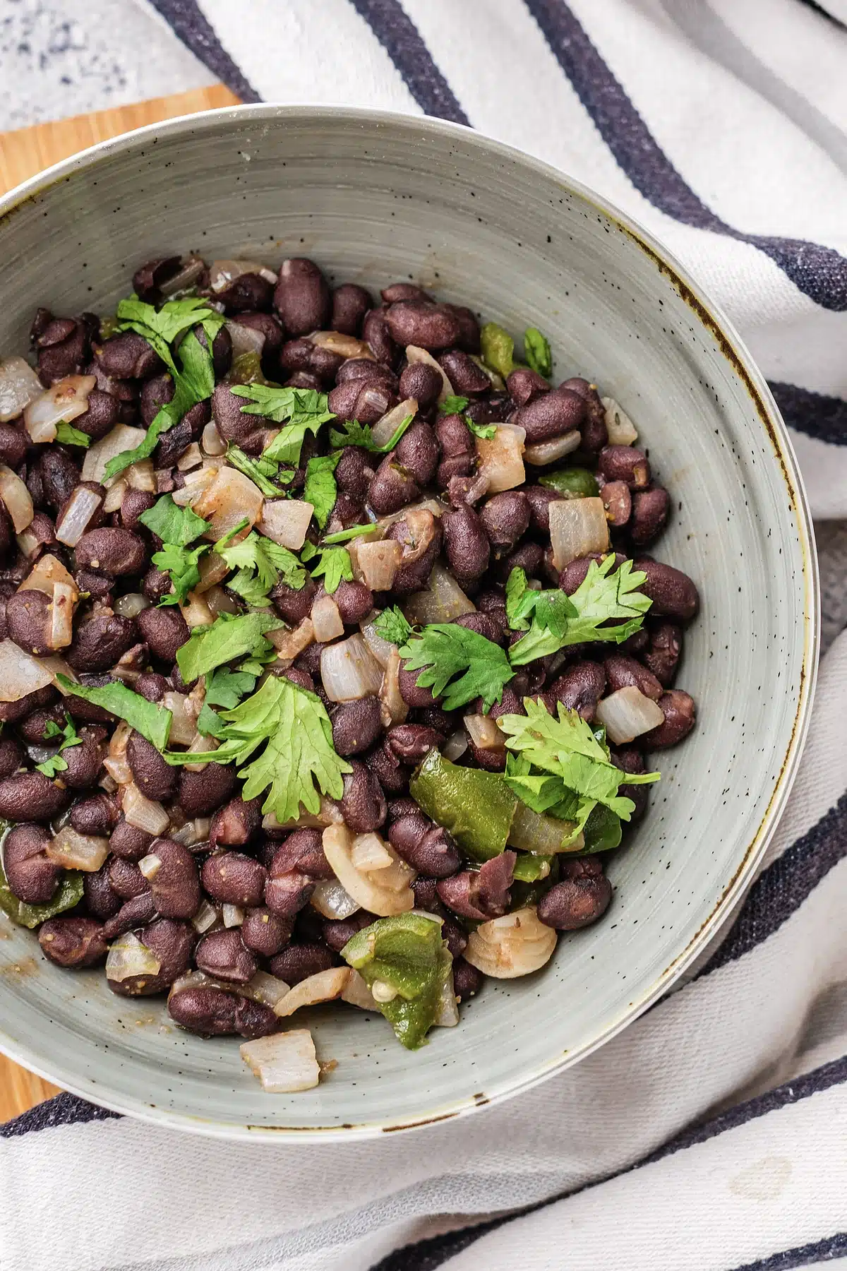 A close view of cuban black beans with onion, pepper and cilantro
