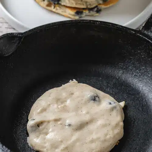 The batter spreading into a round in the hot pan