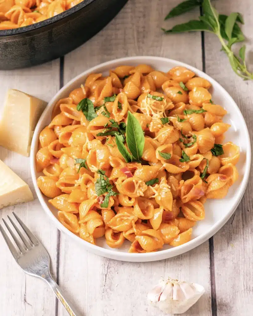 Gigi Hadid pasta with shells on a white plate, seen from directly above with the skillet behind