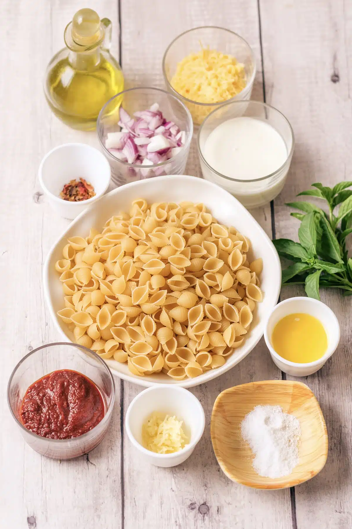 Ingredients for Gigi Hadid pasta: dried shells, tomato paste, heavy cream, olive oil, red onion, garlic, butter, red pepper flakes, Parmesan and salt