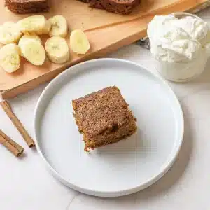 A single square of gingerbread cake on a white plate