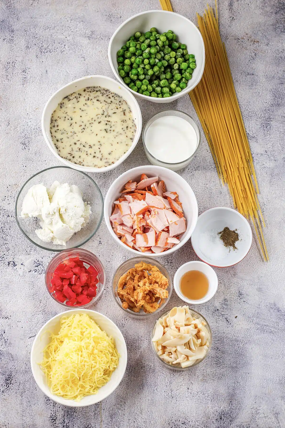 Spaghetti, diced ham, peas, mushrooms and cheddar laid out for ham tetrazzini