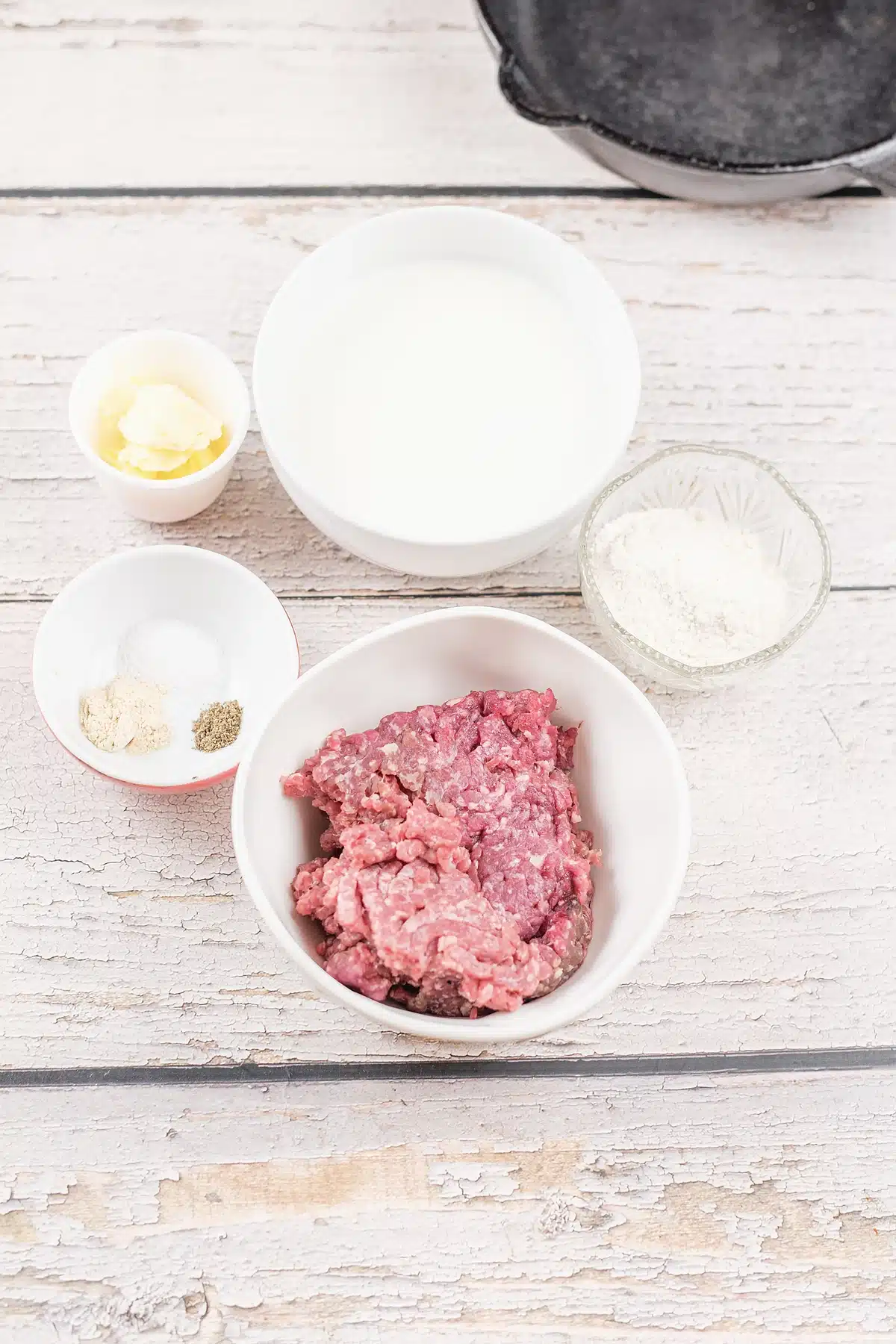 Sausage gravy ingredients with ground pork, milk, butter, flour and black pepper