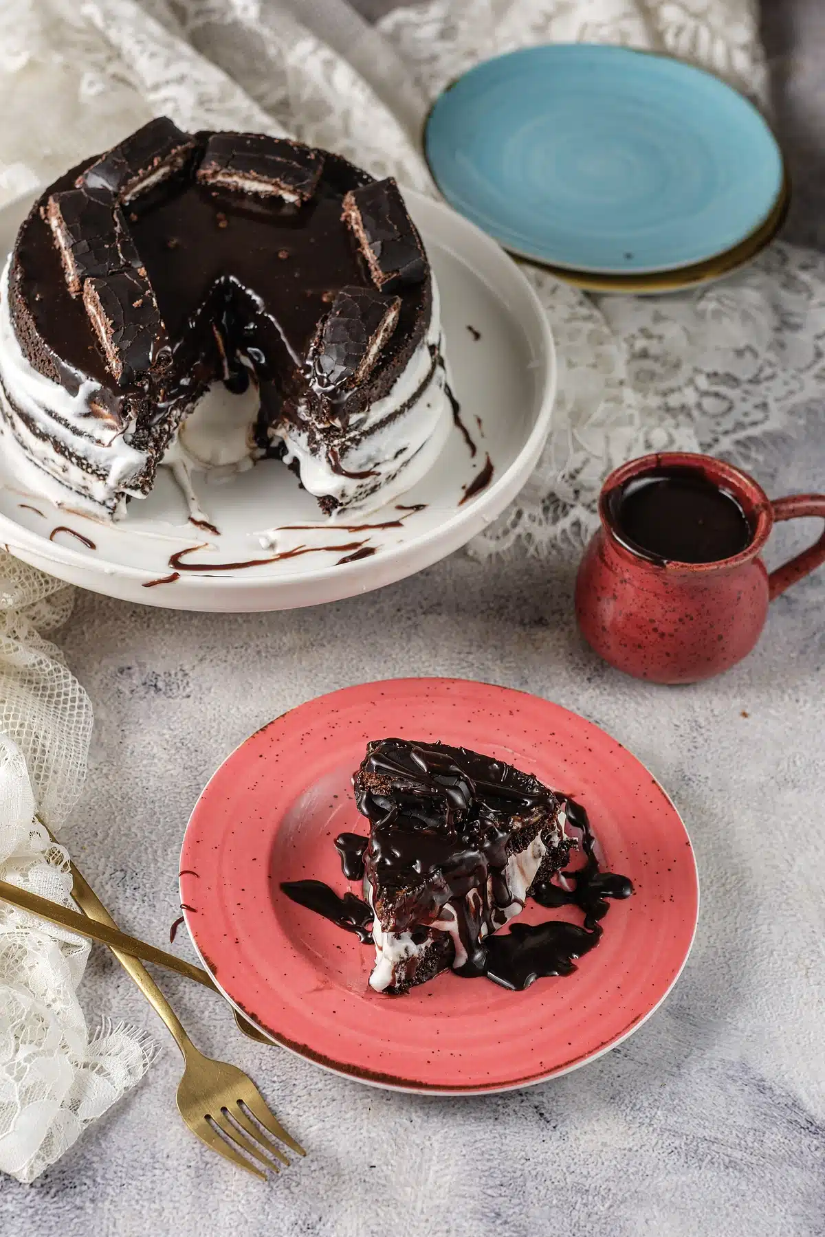 A wedge lifted away from the round, ganache dripping down the cut face