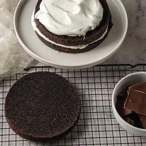A pale cream spread thickly over one baked round, a second round on a rack behind